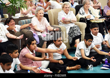 Schulkinder besuchen ein Senioren-Pflegeheim Generationenbeziehungen zu entwickeln. Stockfoto