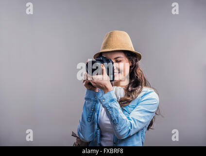 Touristischen Mädchen in Jeanshemd mit Kamera, Studio gedreht Stockfoto