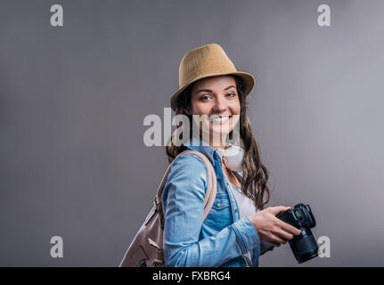 Touristischen Mädchen in Jeanshemd mit Kamera, Studio gedreht Stockfoto