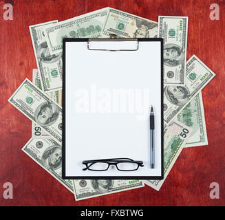 Leeres Papierblatt in Zwischenablage platziert auf Mitte des Geld Dollar und Holz Hintergrund, Business Konzept und Informationen-Mock-up Stockfoto