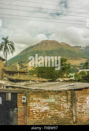 Ländliches Motiv Landschaft Armenhäuser und hohe Berge im Hintergrund von der Autobahn in die Außenseiten von Quito, Ecuador Stockfoto