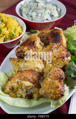 Eine hausgemachte Portion Tandoori Chicken mit Safron Rice und Gurke Riata indischen Stil. Stockfoto