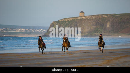 Benone Strand, Downhill, Limavady, Co Londonderry, UK 14. April 2016 Fahrer trainieren ihre Pferde auf Benone Strand. Im Hintergrund ist das ikonische Mussenden Temple auf der Klippe. Bildnachweis: Eoin McConnell/Alamy Live-Nachrichten Stockfoto