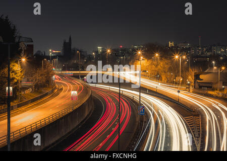 Eine Langzeitbelichtung einer Autobahn in Bristol, die Lichter der Stadt mit einer Kirche im Hintergrund sichtbar. Stockfoto