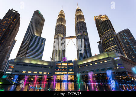 Kuala Lumpur, Malaysia - April: Blick auf die Petronas Twin Towers und bunten Wasserfontänen Stockfoto