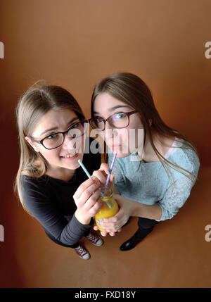 Teen Mädchen zusammen Orangensaft trinken Stockfoto