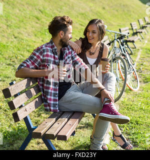 Menschen trinken Kaffee in einen erholsamen Tag im Park auf einer Bank, die Fahrräder neben Ihnen Stockfoto