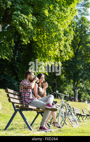 Menschen trinken Kaffee in einen erholsamen Tag im Park auf einer Bank, die Fahrräder neben Ihnen Stockfoto