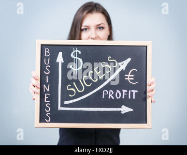 Junge Frau hält Business-Grafik Stockfoto