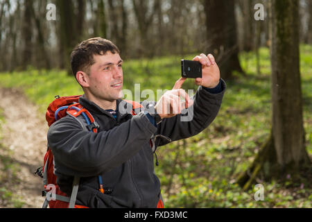 Mann Wanderer nehmen Foto mit Ihrem Smartphone im Wald Stockfoto