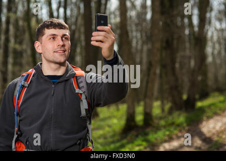 Mann Wanderer nehmen Foto mit Ihrem Smartphone im Wald Stockfoto