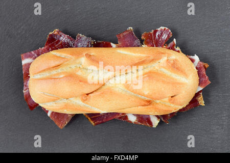 High-Angle Shot von einem spanischen Bocadillo de Jamon, ein Serrano Schinkensandwich auf Schiefer Stein Hintergrund Stockfoto