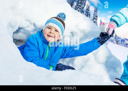 Junge aus Schnee Tunnel im Park gezogen bekommen Stockfoto