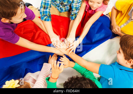 Kinder halten ihre Hände zusammen über die Flagge Stockfoto