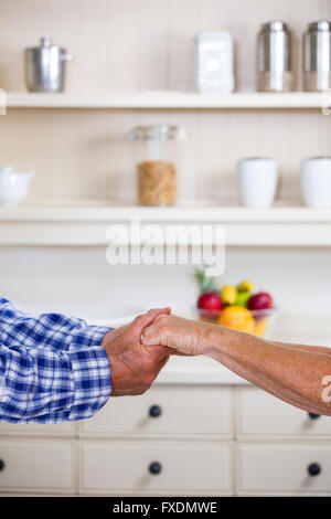 Bild von älteres paar Hand in Hand in der Küche zugeschnitten Stockfoto