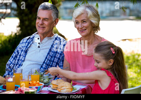 Enkelin mit Grandparants Essen Stockfoto