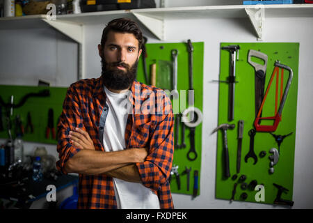 Fahrrad Mechaniker stehend mit Arme gekreuzt Stockfoto