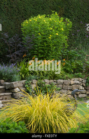 Schöne, traditionelle, gepflegten, ländlichen Garten, West Yorkshire, England - blühende Pflanzen und Sträucher auf erhöhten krautige Grenze im Sommer. Stockfoto