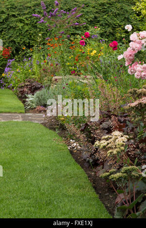 Einen privaten, traditionellen, gepflegten, ländlichen Garten, West Yorkshire, England - krautige Grenze, schönen Blumen und fein säuberlich geschnittenen Rasen. Stockfoto