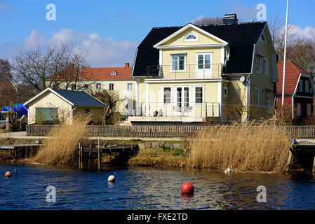 Lyckeby, Schweden - 7. April 2016: Riverside Lyckeby Fluss entlang nach Hause. Gelben und weißen Haus mit schwarzen Dachziegeln. Hölzerne fe Stockfoto