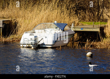 Lyckeby, Schweden - 7. April 2016: White Askeladden 515 offenes Motorboot mit Johnson 90 Motor, festgemacht an einem hölzernen Steg gesehen von t Stockfoto