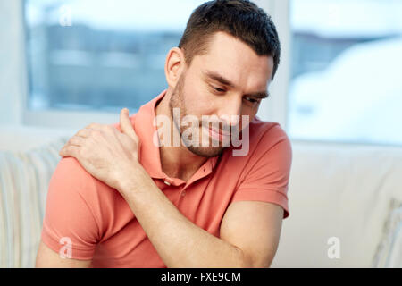 unglückliche Mann leidet unter Nackenschmerzen zu Hause Stockfoto