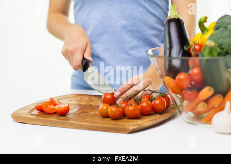 Nahaufnahme von Frau hacken Tomaten mit Messer Stockfoto