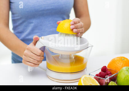 Nahaufnahme von Frau quetschen Fruchtsaft zu Hause Stockfoto