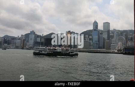 Hong Kong Skyline mit einem Star ferry Kreuzung Victoria Harbor an einem trüben Nachmittag. Stockfoto