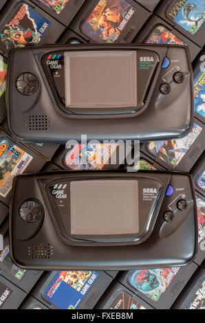 Zwei Sega Game Gear Videospiel Einheiten - die Originalversion von 1990 und die Majesco Version von 2001 - auf einem Bett von Patronen. Stockfoto