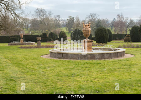 Brunnen und Formschnitt in den Süd-Gärten in Burghley House, ein Landhaus aus dem 16. Jahrhundert, Stamford, England, Vereinigtes Königreich. Stockfoto