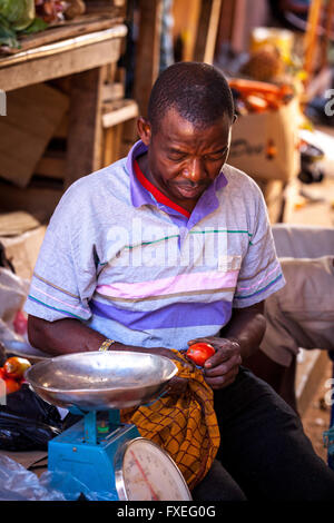 Mosambik, Afrika, ein Mann, der Verkauf von Gemüse auf dem Markt in der Stadt. Stockfoto