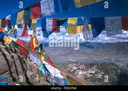 China, Tibet, Lhasa, Gokpori Ridge, bunte Gebetsfahnen am steilen Berghang mit Blick auf das Kloster Ganden Komplex, mit dramatischen Bergkulisse fliegen. Stockfoto