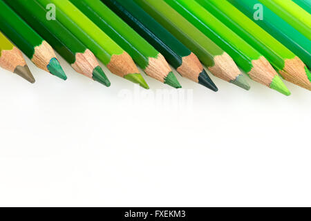 Buntstifte mit verschiedenen Schattierungen von Grün mit textfreiraum liegen in den oberen Rand des Fotos. Foto ist nicht isoliert. Stockfoto