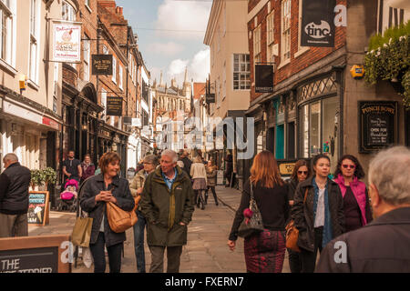 Ein Blick auf die belebte Stonegate-Straße in der historischen Stadt York, North Yorkshire, England, UK mit York Minster im Hintergrund Stockfoto