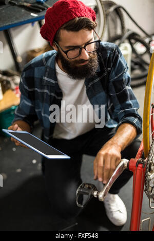 Fahrradmechaniker Blick auf Tablet-computer Stockfoto