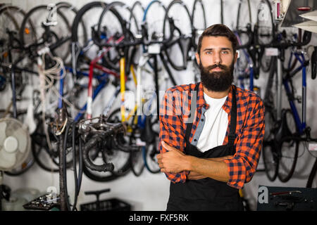 Fahrrad Mechaniker stehend mit Arme gekreuzt Stockfoto