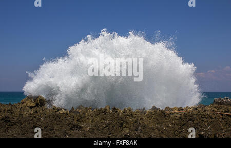 Riesige Welle spritzt gegen eine Felswand erstellen weißen Schaum. Bali, Indonesien, Asien Stockfoto