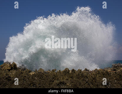 Riesige Welle spritzt gegen eine Felswand erstellen weißen Schaum. Bali, Indonesien, Asien Stockfoto