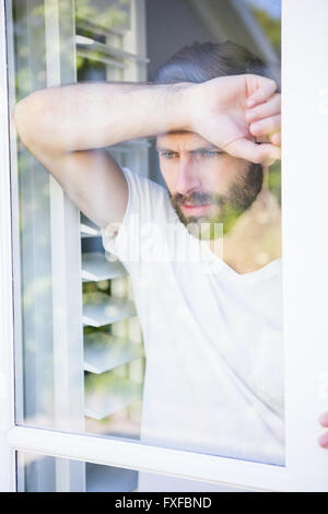 Deprimiert Mann stützte sich seinen Kopf auf Fensterglas Stockfoto
