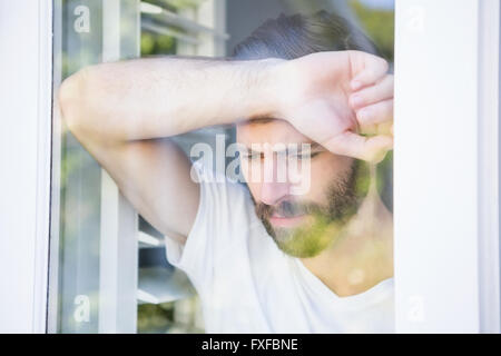 Deprimiert Mann stützte sich seinen Kopf auf Fensterglas Stockfoto