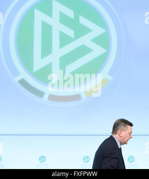 Neu gewählte geht Präsident des deutschen Fußball-Bundes (DFB), Reinhard Grindel, vorbei an dem DFB-Logo nach seiner Wahl während der außerordentlichen DFB-Bundestag (National Conference) in Frankfurt/Main, Deutschland, 15. April 2016. Foto: Arne Dedert/dpa Stockfoto