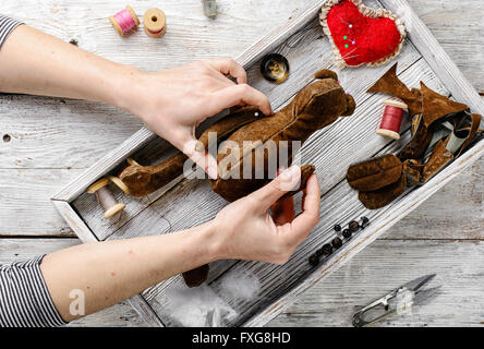 Die Hände von Frauen in den Prozess der Herstellung von weichen zu tragen, Spielzeug und Nähwerkzeuge Stockfoto