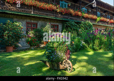 Altes Bauernhaus, Balkon mit Geranien (Pelargonium spec.), vor einem Blumengarten, Bauerngarten, Piesenkam, Isarwinkel Stockfoto