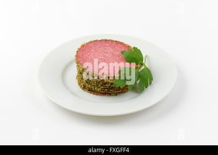 Stapel Scheiben Pfeffer Salami auf weißen Teller Stockfoto