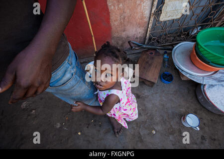 Mosambik, Pemba, Afrika, ein kleines Mädchen umarmt seinen Vater Bein. Stockfoto