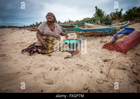 Mosambik, Afrika, eine Frau am Strand ist das Kochen, weißen Sandstrand, bewölkten Himmels. Stockfoto