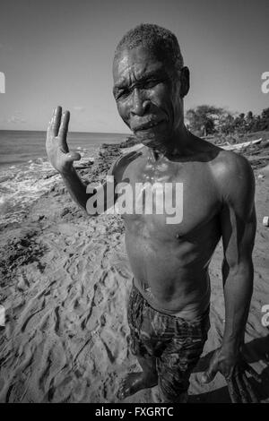 Mosambik, Mann sagt Hallo am Strand, weißer Sand, schwarz / weiß, B&W. Stockfoto