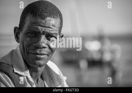 Mosambik, Afrika, ein Porträt von gebräunter Haut lächelnd Mann, schwarz und weiß, B&W. Stockfoto