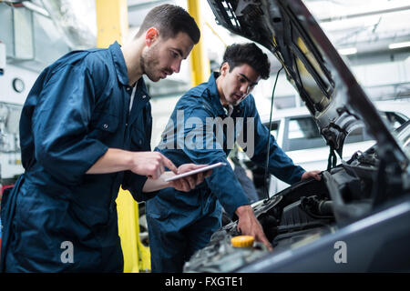 Mechanik Prüfung Automotor mit digital-Tablette Stockfoto